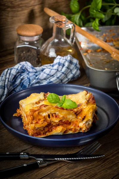 Pezzo di gustose lasagne calde con vino rosso. — Foto Stock