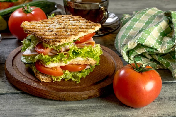 Бутерброд з шинкою, огірком, помідорами та салатом . — стокове фото