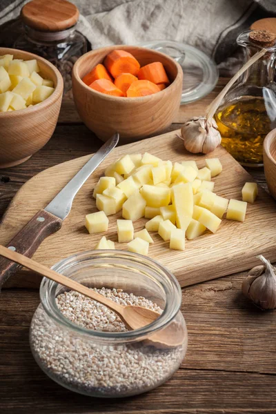 Patatas cortadas en cubitos en una tabla de cortar madera . — Foto de Stock