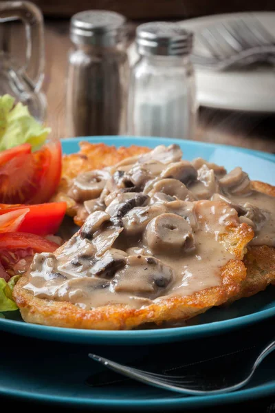 Crispy fried homemade potato pancakes with mushroom sauce. — Stock Photo, Image