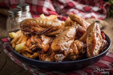 Fırında tavuk kanadı patates kızartması ile.