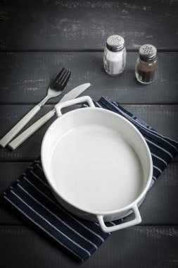 Karanlık bir tezgah üzerinde pişirme için boş tabak.