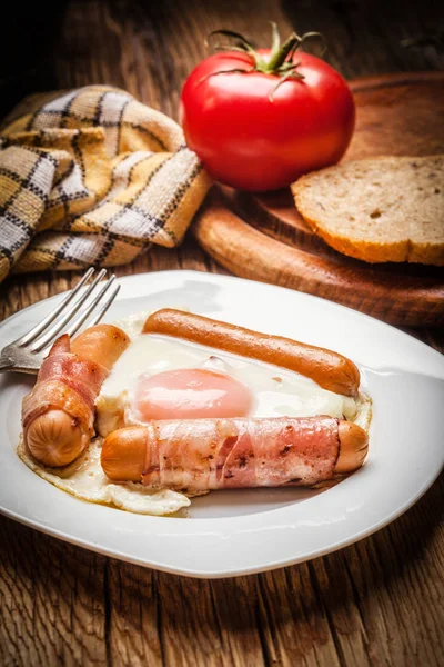 Fried eggs with sausages and bacon. — Stock Photo, Image