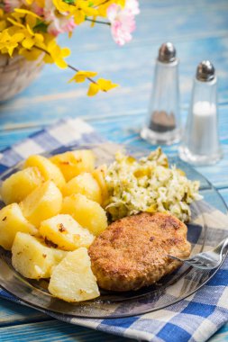 Kızarmış domuz pirzolası haşlanmış patates ve salata ile.