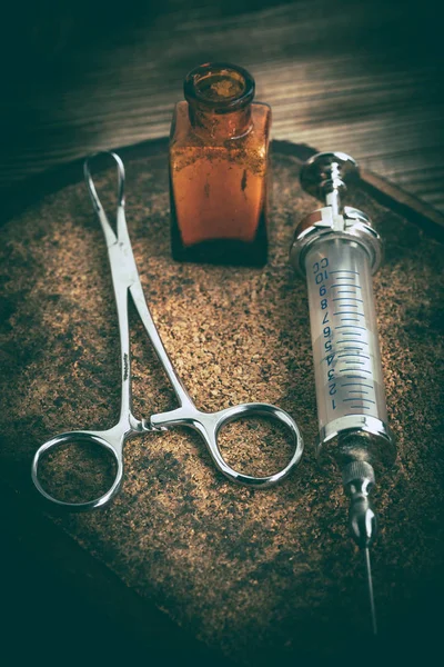 Old medicine equipment on wooden background.