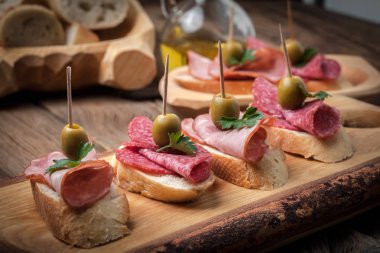 Tapas dilimlenmiş sosis, salam, zeytin ve maydanoz ile.