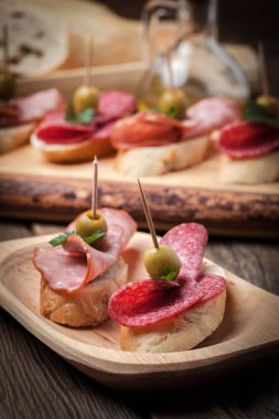Tapas dilimlenmiş sosis, salam, zeytin ve maydanoz ile.