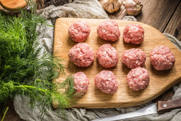 Raw meatballs on the wooden cutting board. — Stock Photo, Image