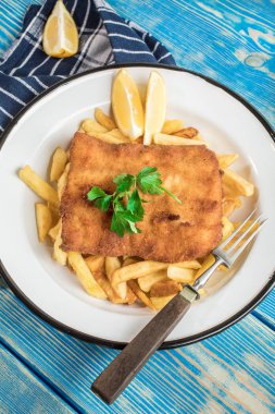 Tabağında patates kızartması olan kızarmış morina balığı..