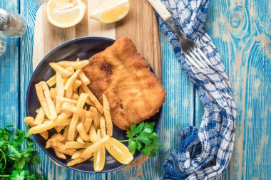 Tabağında patates kızartması olan kızarmış morina balığı..