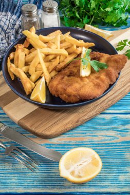 Tabağında patates kızartması olan kızarmış morina balığı..