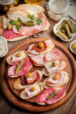 Tapas dilimlenmiş sosis, salam, zeytin ve maydanoz ile.