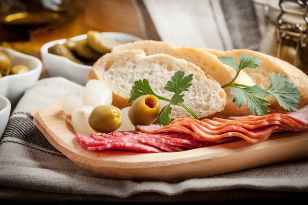 Tapas i plasterki kiełbasa, salami, oliwki, marynowane cebule, cuc — Zdjęcie stockowe