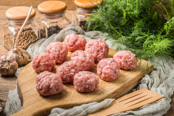 Raw meatballs on the wooden cutting board. — Stock Photo, Image