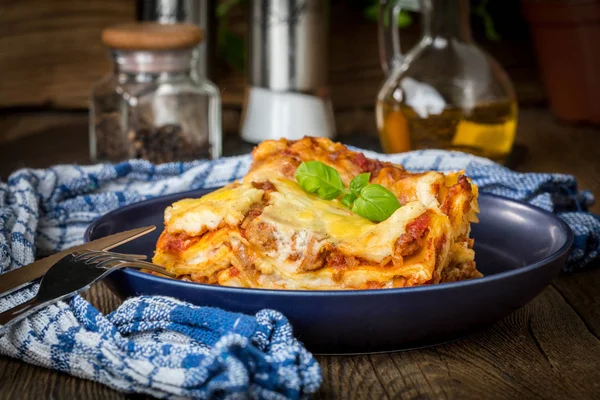 Pezzo di gustose lasagne calde con vino rosso. — Foto Stock