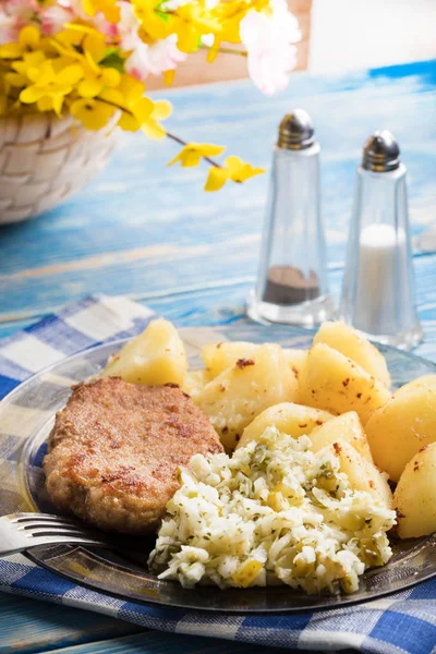 Fried pork chop with boiled potatoes and salad. Royalty Free Stock Images