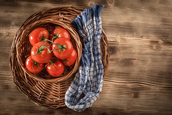 Verse tomaten in een rieten mand. — Stockfoto
