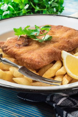 Tabağında patates kızartması olan kızarmış morina balığı..