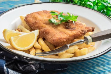 Tabağında patates kızartması olan kızarmış morina balığı..