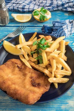 Tabağında patates kızartması olan kızarmış morina balığı..