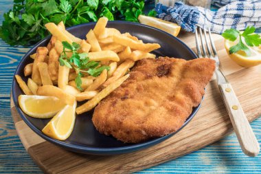 Tabağında patates kızartması olan kızarmış morina balığı..