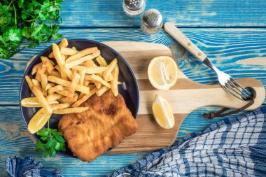 Tabağında patates kızartması olan kızarmış morina balığı..