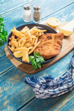 Tabağında patates kızartması olan kızarmış morina balığı..