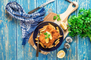 Tabağında patates kızartması olan kızarmış morina balığı..