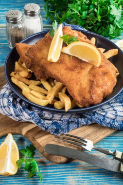 Tabağında patates kızartması olan kızarmış morina balığı..