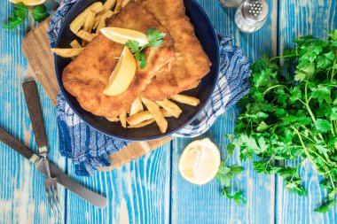 Tabağında patates kızartması olan kızarmış morina balığı..