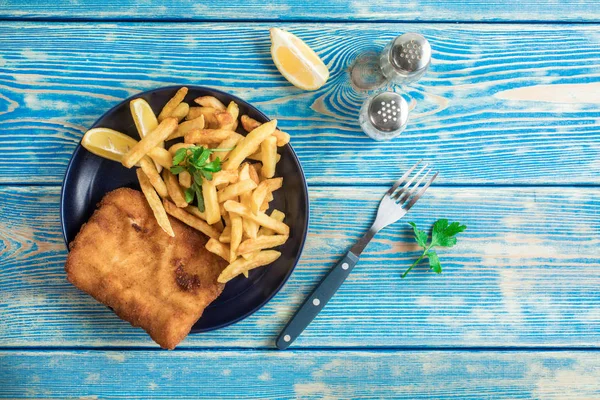 A piece of fried cod with fries on a plate. — Stock Photo, Image