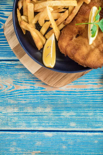 A piece of fried cod with fries on a plate. — Stock Photo, Image