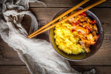 Ahşap tab tavuk ve sebze parçaları ile safran pirinç