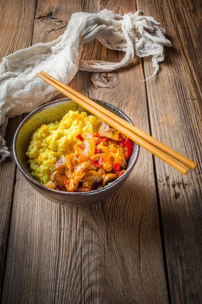 Arroz de azafrán con trozos de pollo y verduras en lengüeta de madera — Foto de Stock