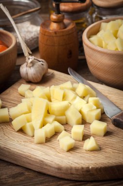 Ahşap doğrama tahtası üzerinde doğranmış patates.