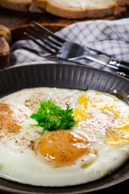 Gri arka planda kahvaltıda kızarmış yumurta ve ekmek..