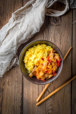 Ahşap tab tavuk ve sebze parçaları ile safran pirinç