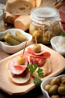 Tapas dilimlenmiş sosis, salam, zeytin ve maydanoz ile.