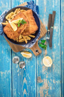 Tabağında patates kızartması olan kızarmış morina balığı..