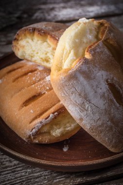 Ahşap masada peynir ile tatlı çörekler.