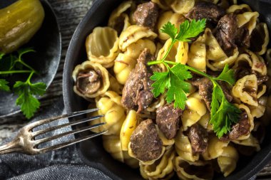 Biftek soslu İtalyan makarna kabukları dökme demir tavada..