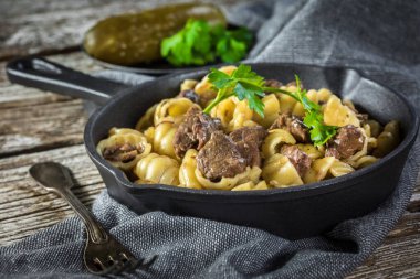 Biftek soslu İtalyan makarna kabukları dökme demir tavada..