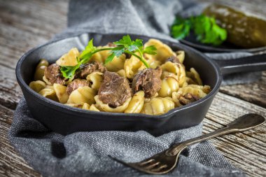 Biftek soslu İtalyan makarna kabukları dökme demir tavada..