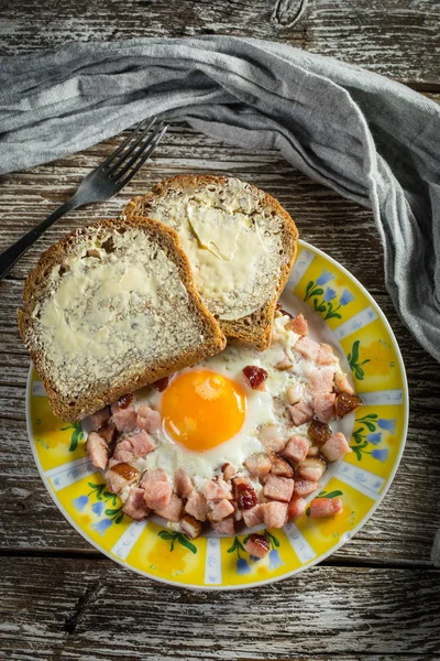 Gebratene Eier mit Schinken auf altem Holzgrund. — Stockfoto