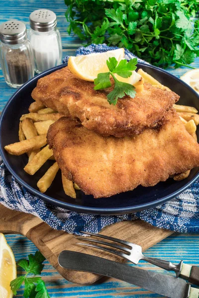 A piece of fried cod with fries on a plate. — Stock Photo, Image