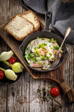 Ahşap arka planda jambonlu sahanda yumurta.. 