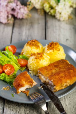 Pirzola, domuz jambonlu, haşlanmış patates ve tabakta salata..