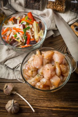 Çiğ tavuk fileto meme parçalar halinde kesilmiş ve cam kapta baharatlı. Küçük alan derinliği.