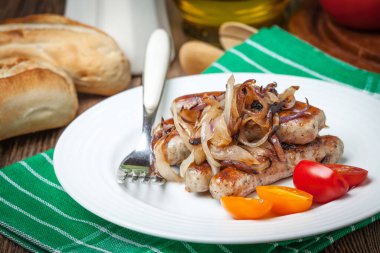 Kızarmış beyaz sosis tabakta soğan ile. Seçici odak.