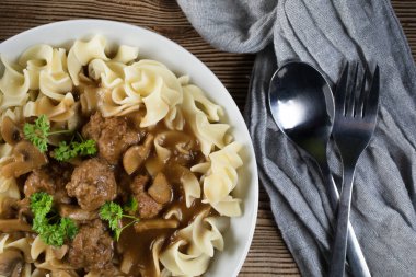 Tagliatelle yosunuyla servis edilen kendi soslu mantarlı domuz köftesi..